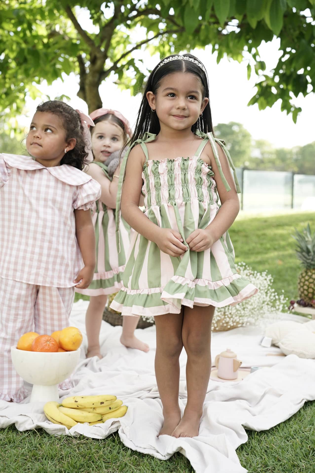 Una niña con un conjunto de Le Petit Marché, fotografiada al aire libre.