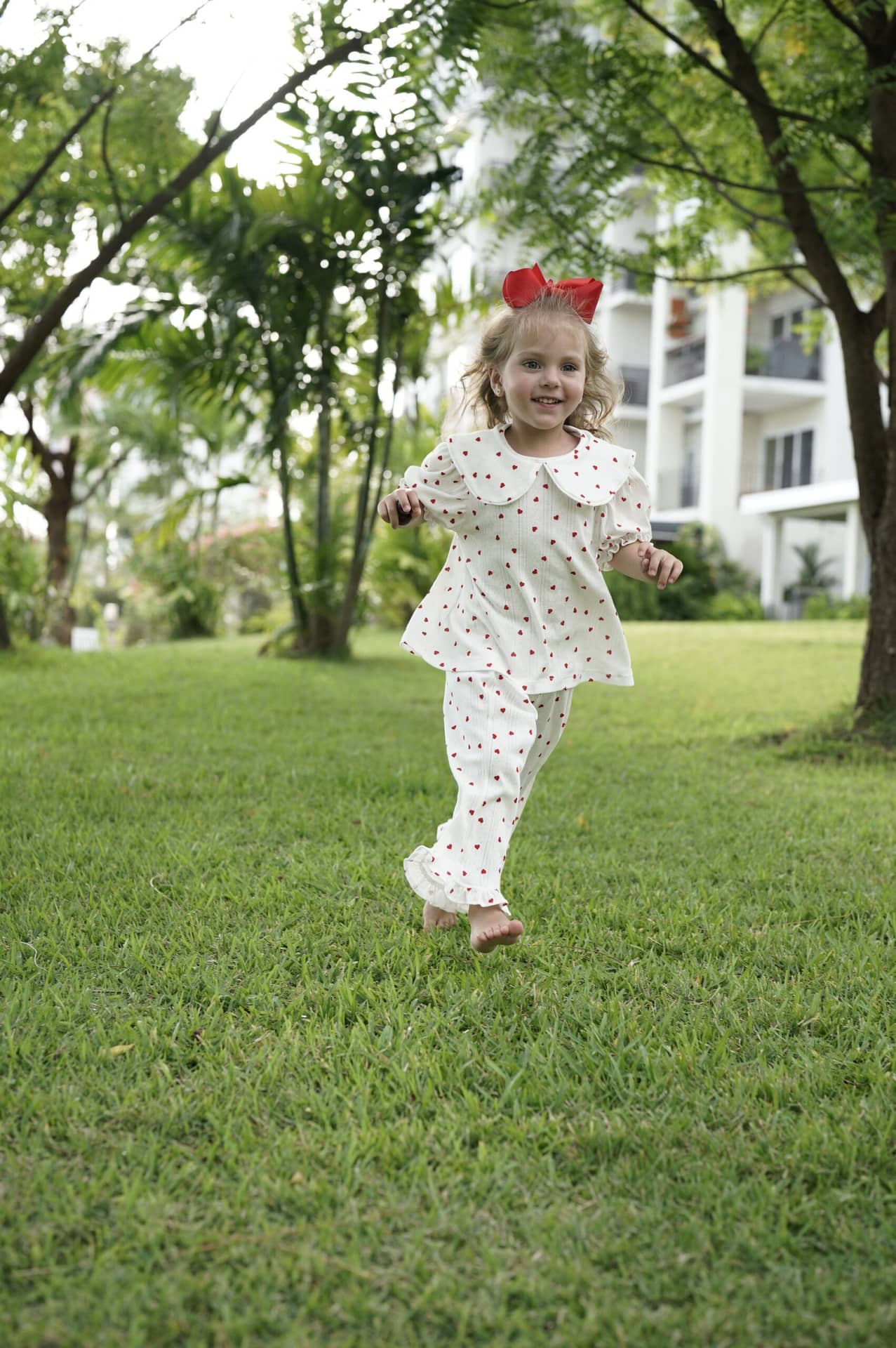 Una niña con un vestido de Le Petit Marché al aire libre.